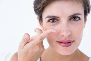 Pretty woman applying contact lens
